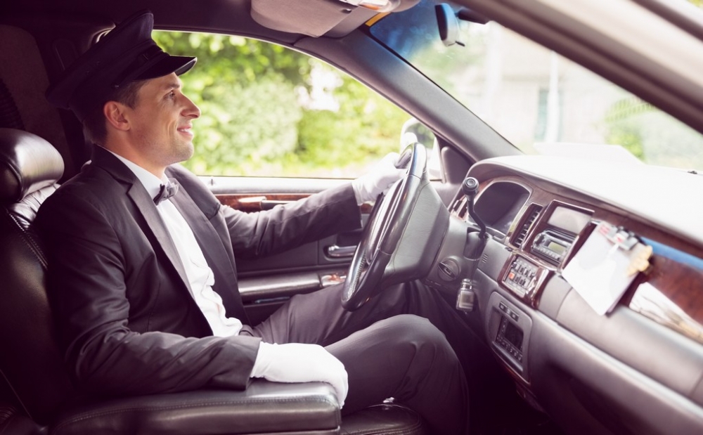 Limousine driver driving and smiling in his limousine